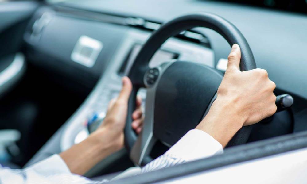 車を運転する人（ハンドル部分）